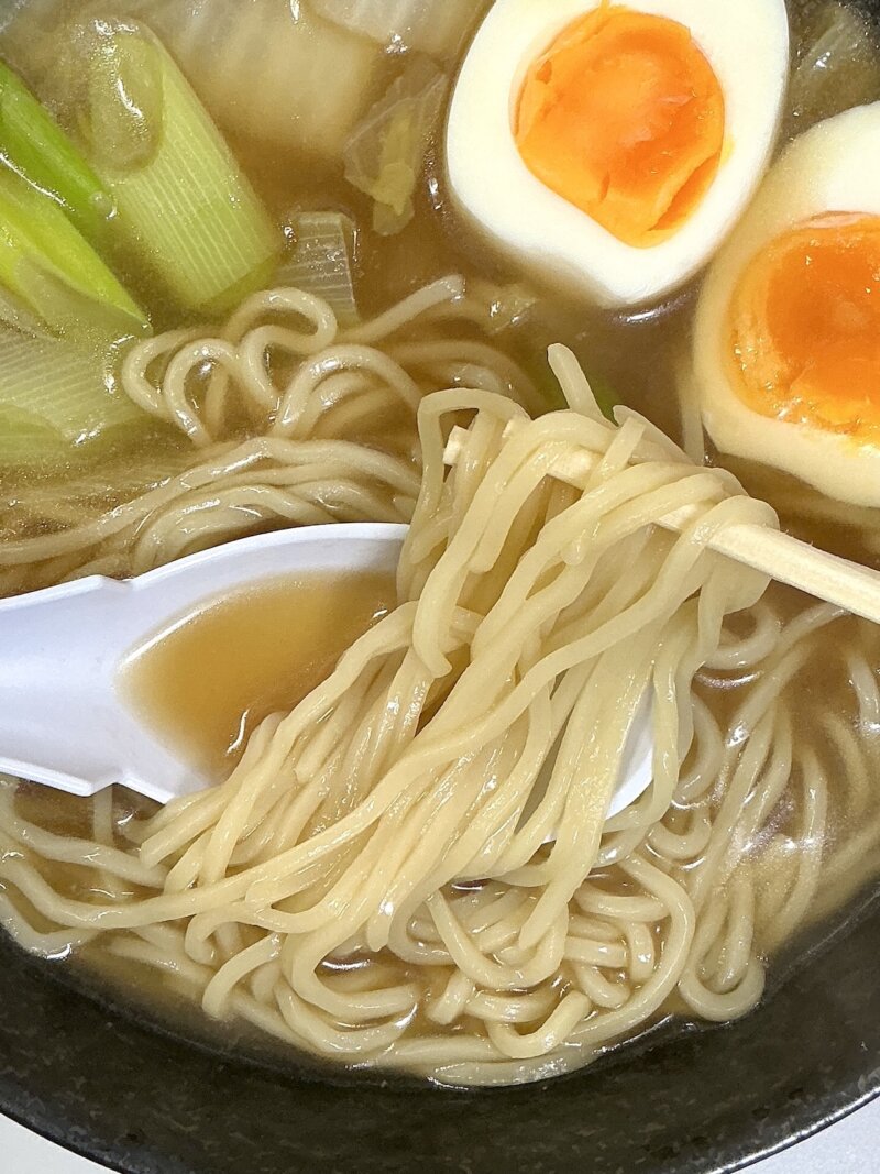 551蓬莱の冬季限定煮込み麺の麺を割り箸で取っている様子