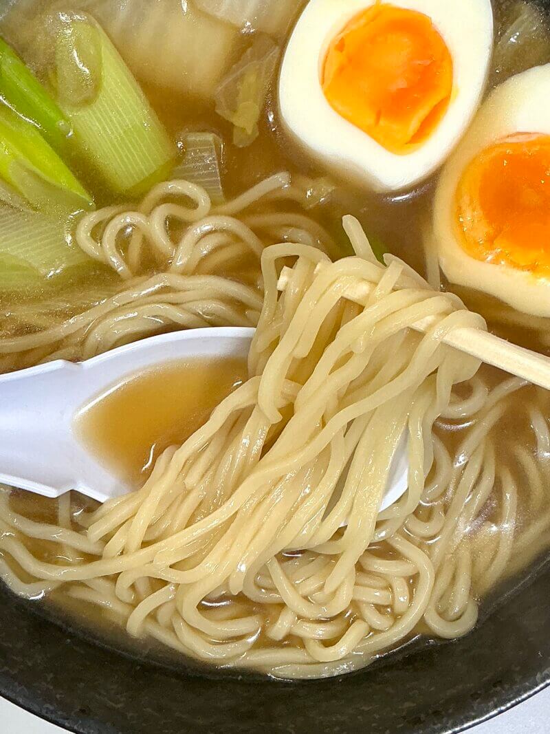 551蓬莱の冬季限定煮込み麺の出来上がった麺を割り箸で取っている様子