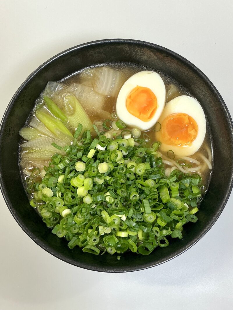 551蓬莱の冬季限定煮込み麺にカットネギをたくさんトッピングした写真