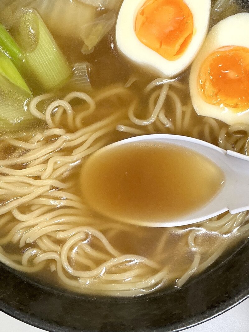 551蓬莱の冬季限定煮込み麺のスープを掬っている様子