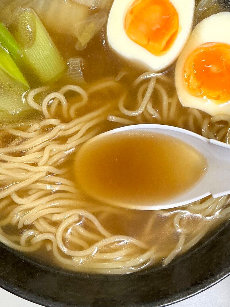 551蓬莱の冬季限定煮込み麺の出来上がったスープを掬っている様子