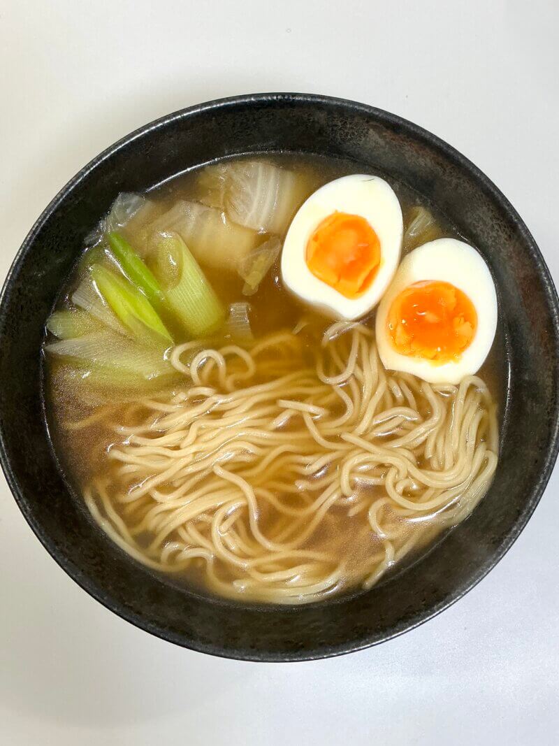 551蓬莱の冬季限定煮込み麺を5分煮込んで器に盛り付け、ゆで卵をトッピングした写真