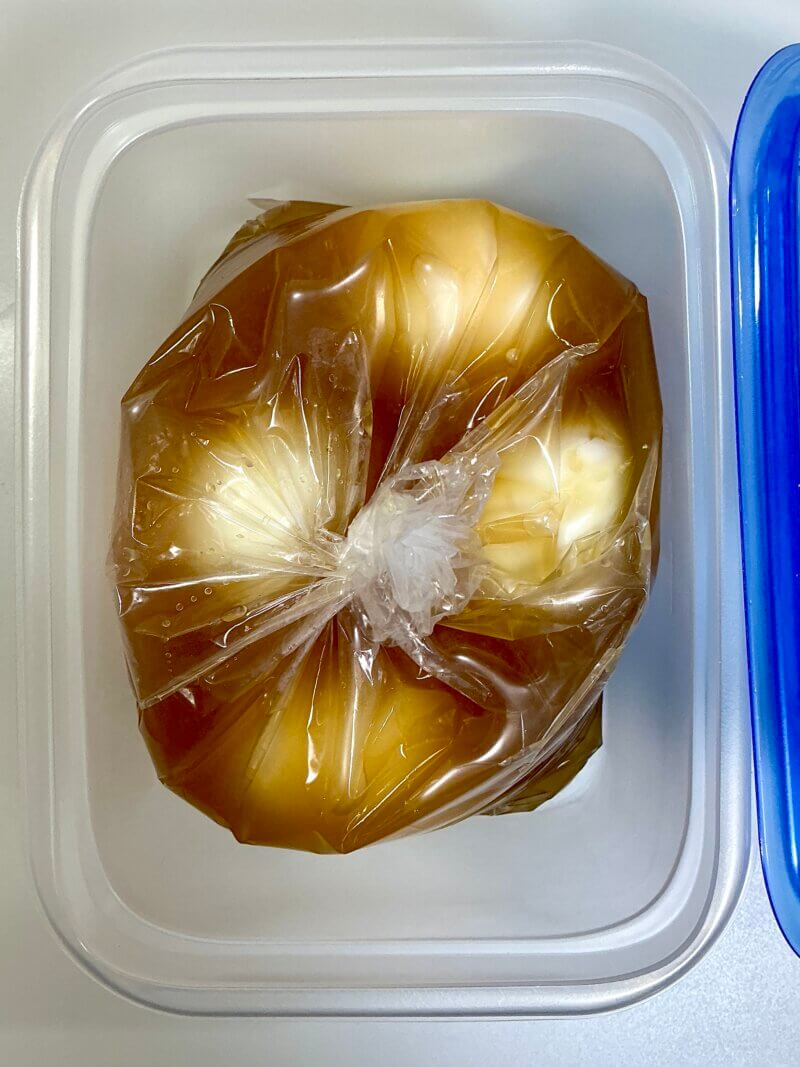 551蓬莱の冬季限定煮込み麺の余ったスープにゆで卵を漬けて煮卵を作っているところ