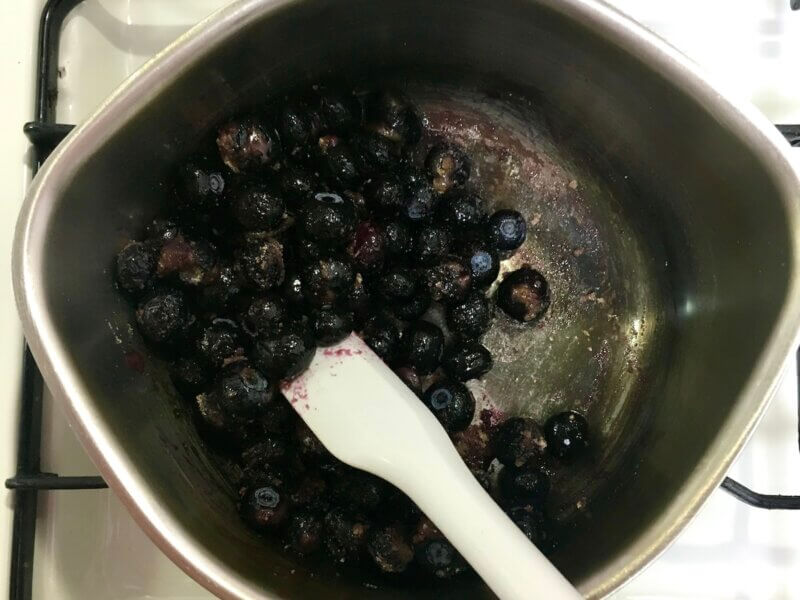 冷凍ブルーベリーと砂糖をヘラで混ぜているところ