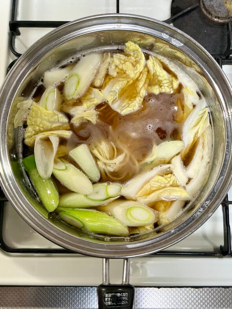 551蓬莱の冬季限定煮込み麺を鍋で煮込んでいるところの写真
