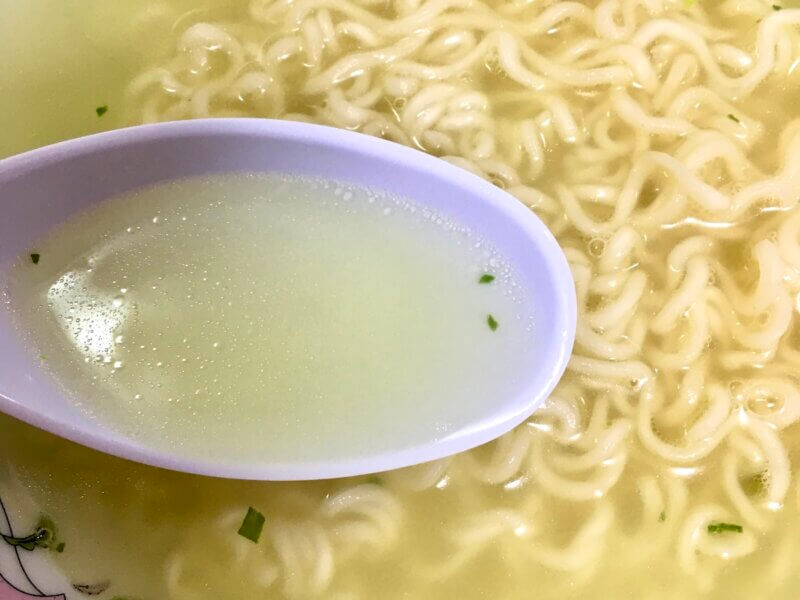 サッポロ一番塩ラーメンのスープをレンゲで掬ったところ