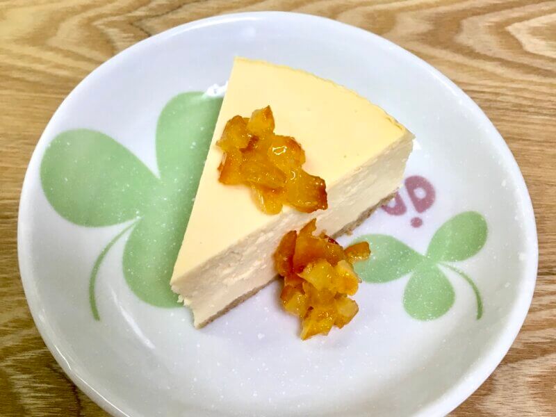 ニューヨークチーズケーキの上に刻みオレンジピールを乗せている様子