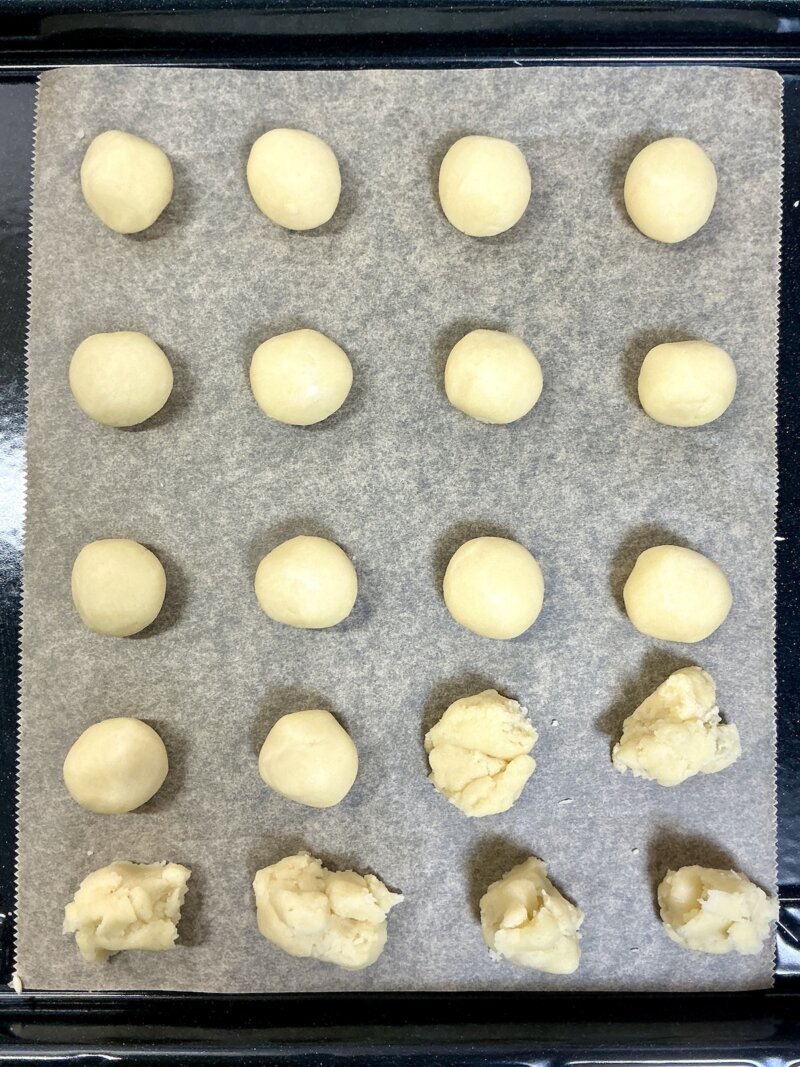 天板の上にスノーボールクッキー生地を丸めて並べている様子