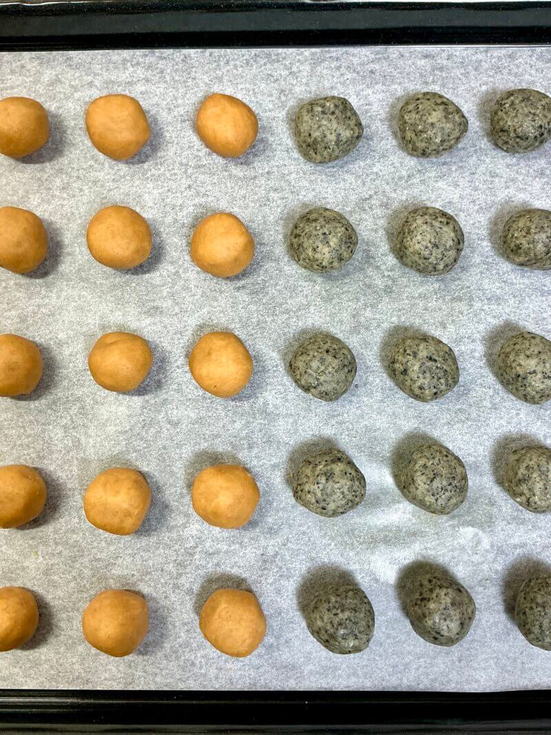 クッキー生地を丸めて天板に並べている様子（きなこ味と黒ごま味）