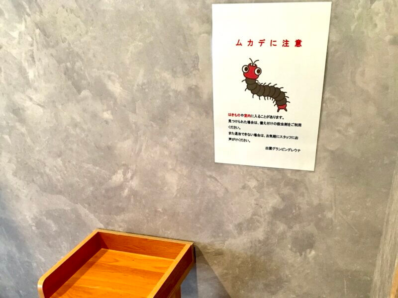 「ムカデに注意」の注意書きが壁に貼ってある様子