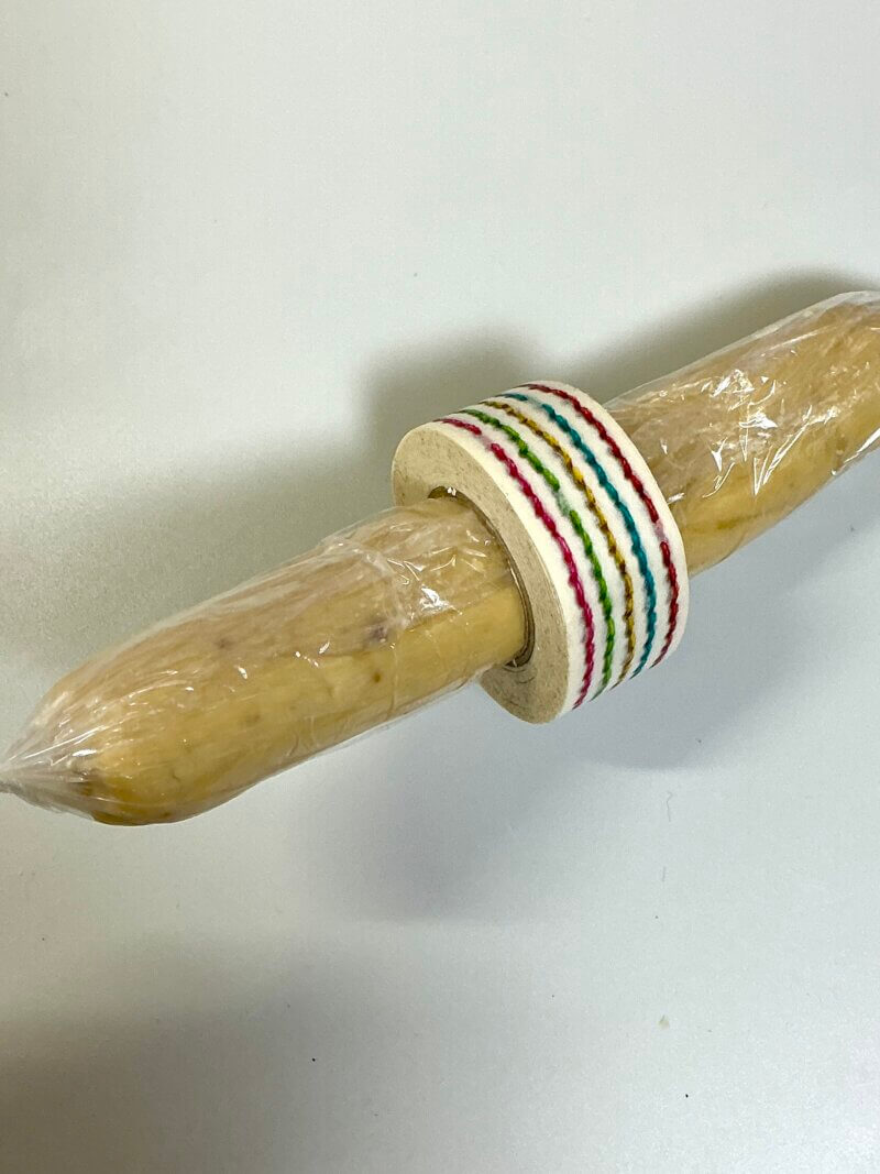 ラップに包んで棒状にしたクッキー生地をマスキングテープに通してキレイな円柱にしている様子