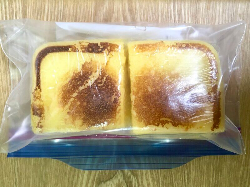 チーズ蒸しパンをラップで包んで保存袋に入れているところ