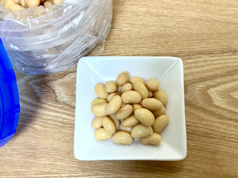 完成した水煮大豆をお皿に盛り付けている様子