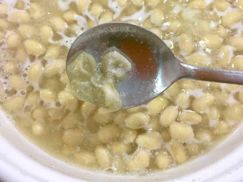 大豆を煮込んで20分後に薄皮を取っているところ
