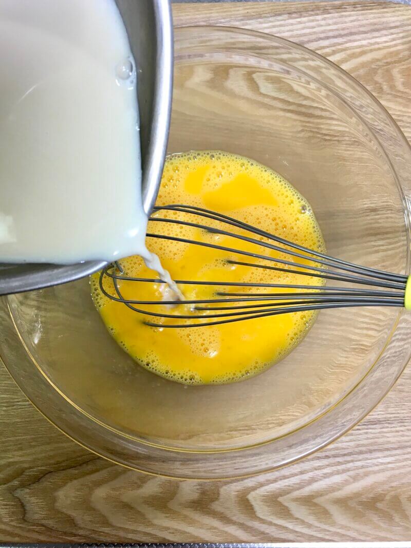溶き卵に温めた牛乳を少し入れて混ぜている様子