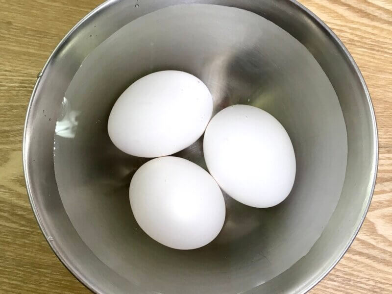 卵3個を常温に戻すため、35〜40℃のお湯につけている様子