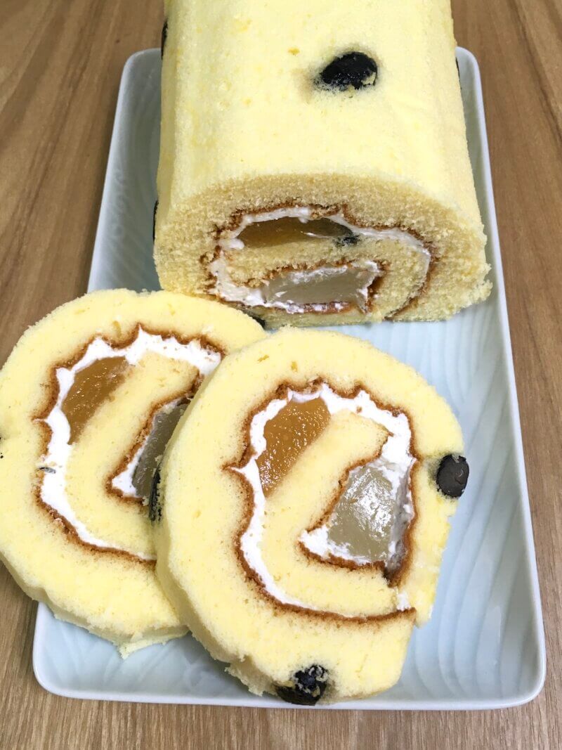 岡山土産「おかやまロール」をカットして中身を見せている様子