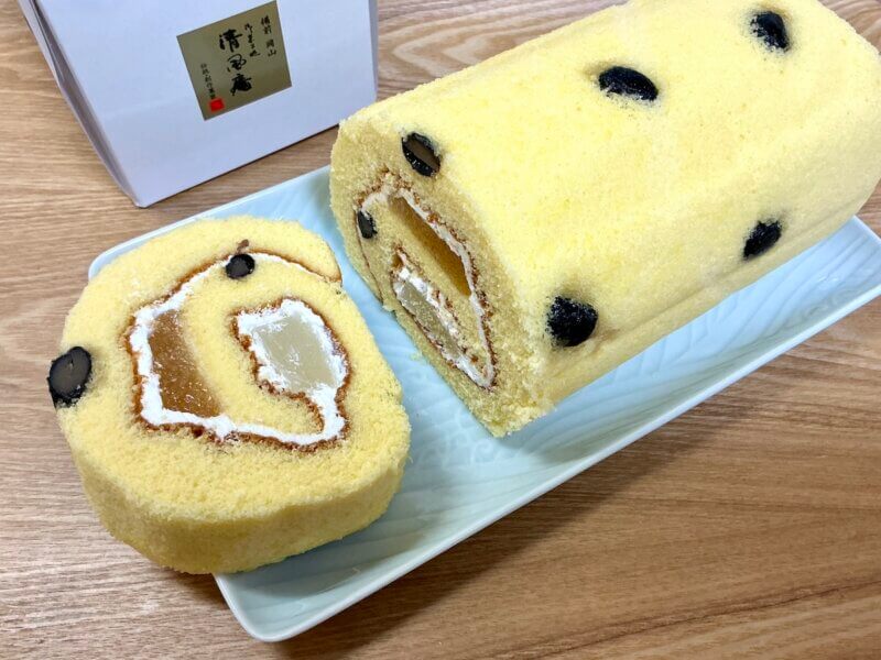 岡山土産「おかやまロール」をカットして中身を見せている様子