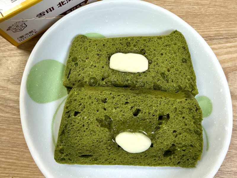 焼いた抹茶蒸しパンにバターを塗っているところ
