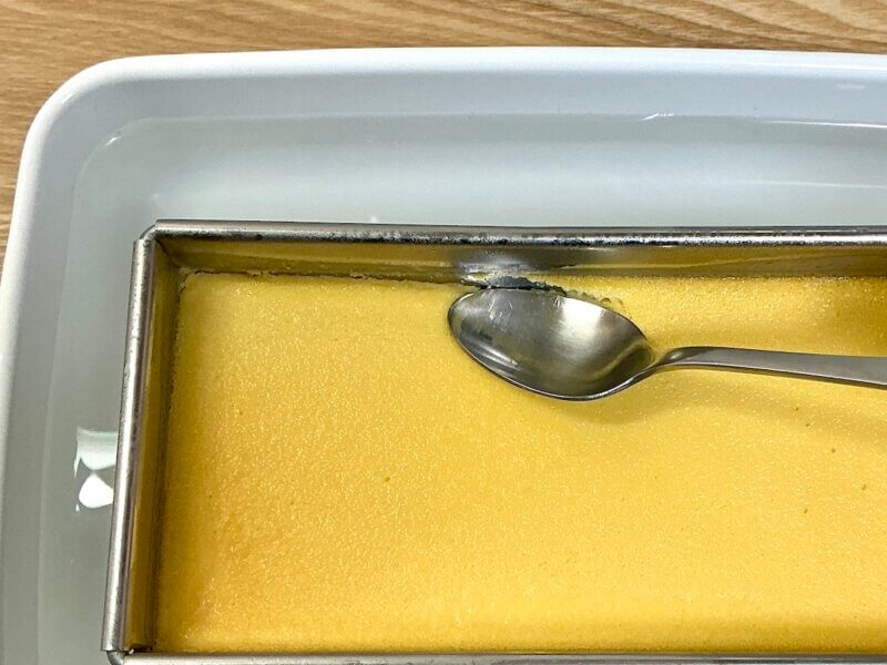 スプーンでプリンの端を剥がしている様子